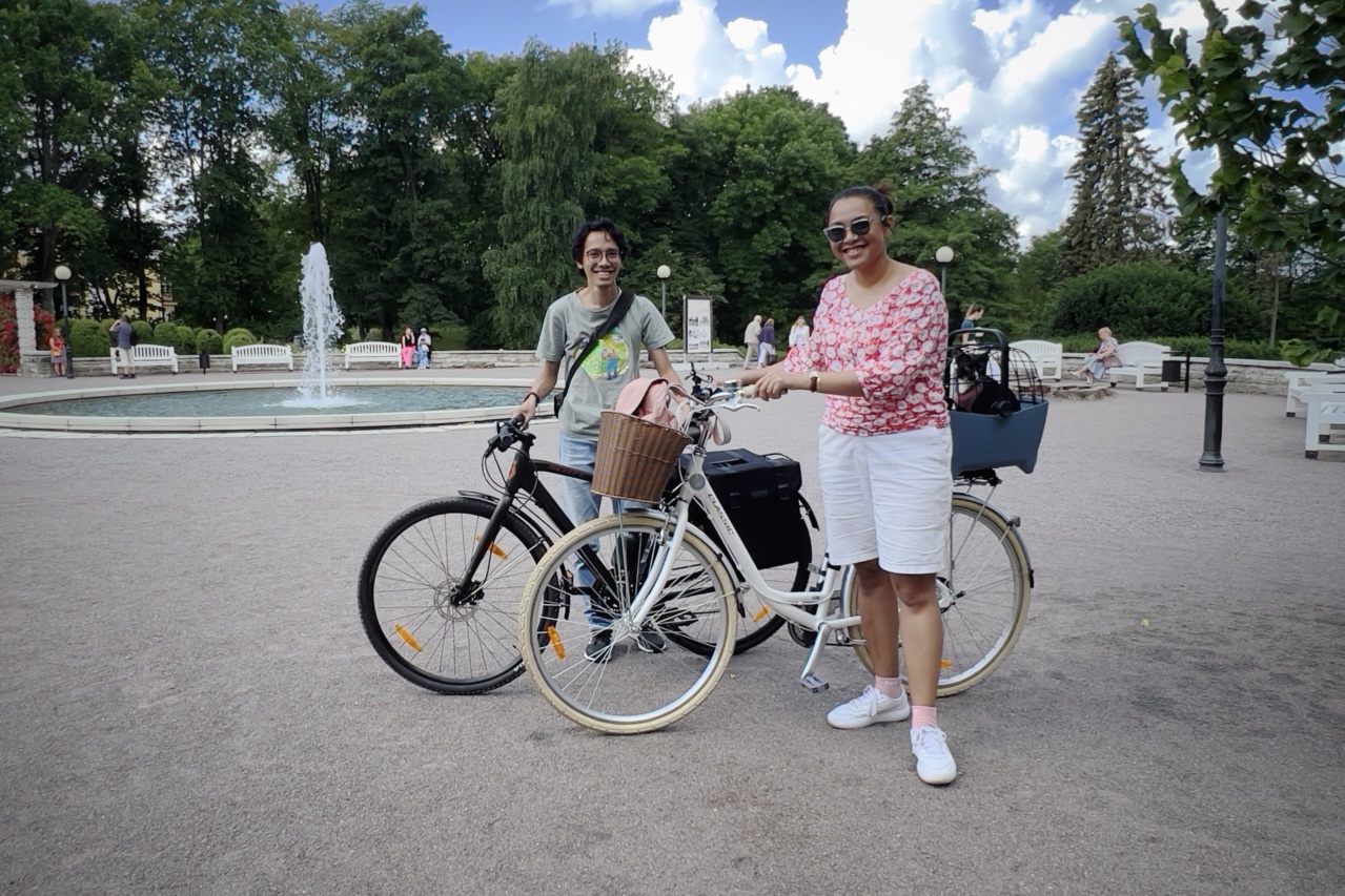 Two people standing with their bikes.